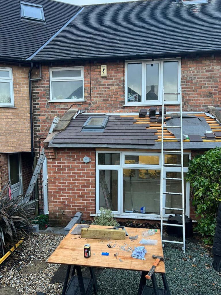 This is a photo taken from the roof ridge looking down a tiled pitched roof on to a flat roof. Works carried out by Burntwood Roofing Repairs